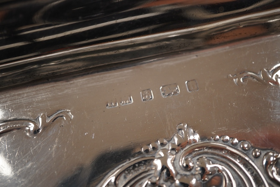 An Edwardian embossed silver dressing table tray, by Henry Matthews, Birmingham, 1901, length 32.1cm, 16.8oz.